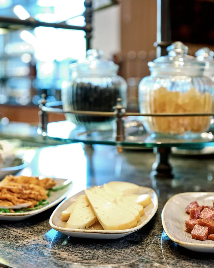 Buffet mit Käsescheiben, Salami, frittiertem Essen und Gläsern mit Snacks